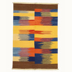 6x9 hand-knotted kilim flatweave and colorful geometric-patterned rug with brown, blue, orange, and yellow colors on a white background.